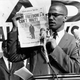 Malcolm X holds up a paper for the crowd to see during a Black Muslim rally in New York City on Aug. 6, 1963.